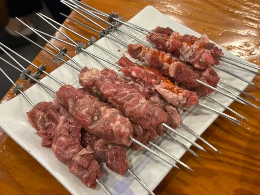 Lamb skewers placed on the auto-rotating grill