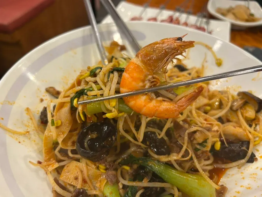 Mala xiangguo served with a bowl of rice on the side