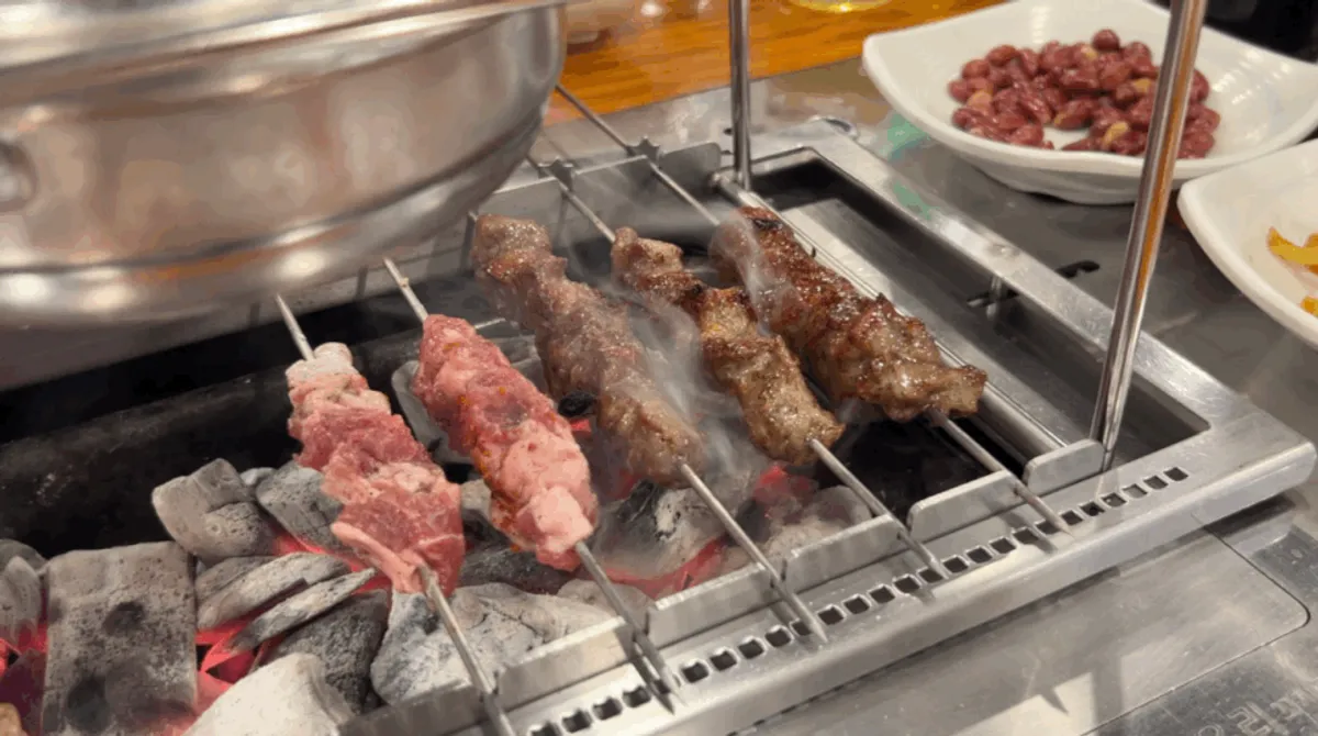 Dinner table filled with lamb skewers and mala xiangguo