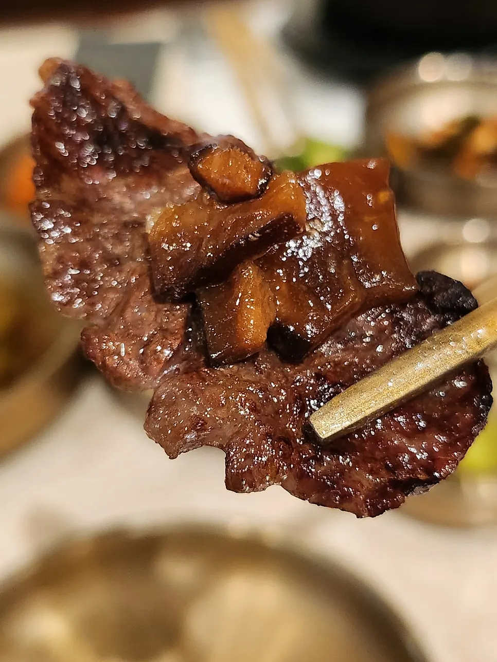 A bite of rib meat wrapped with scallion kimchi