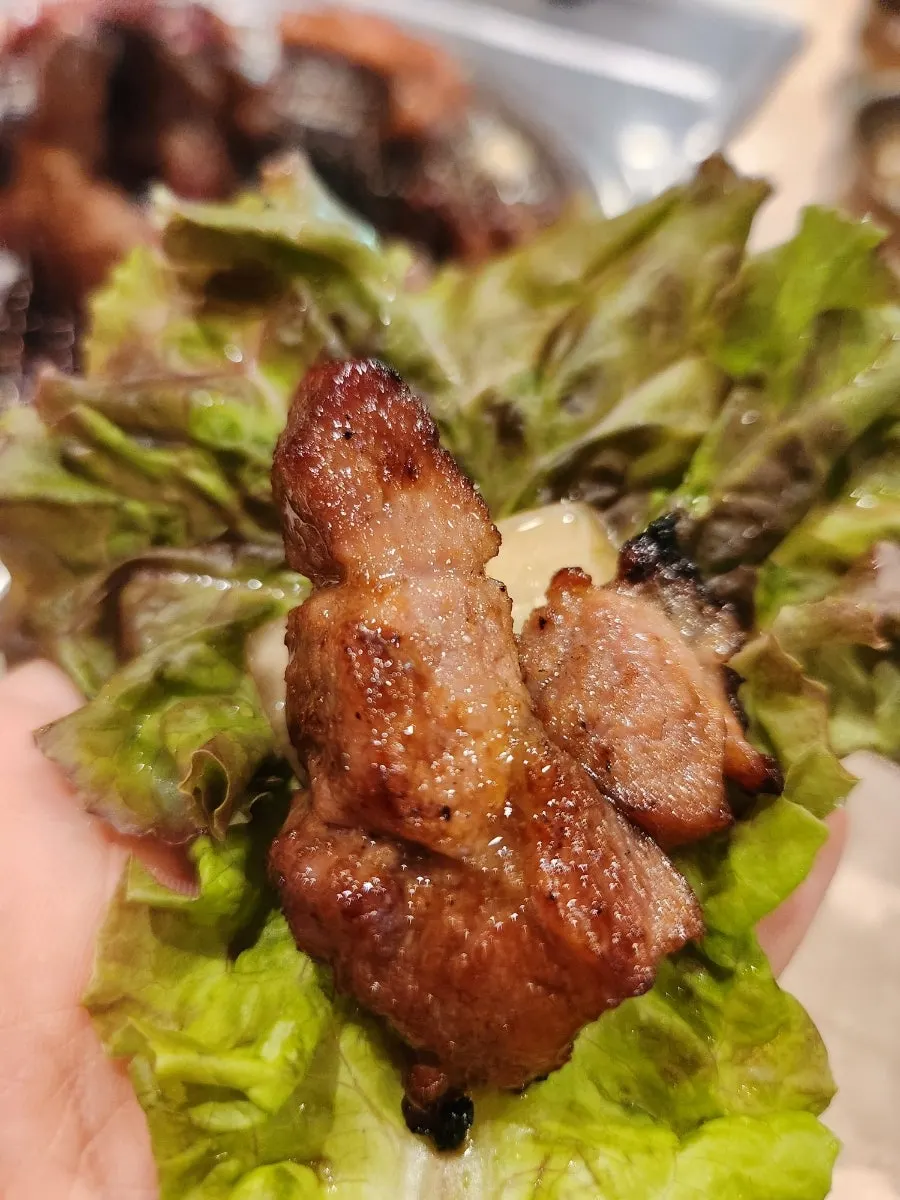 집게로 집어 든 돼지갈비 한 점