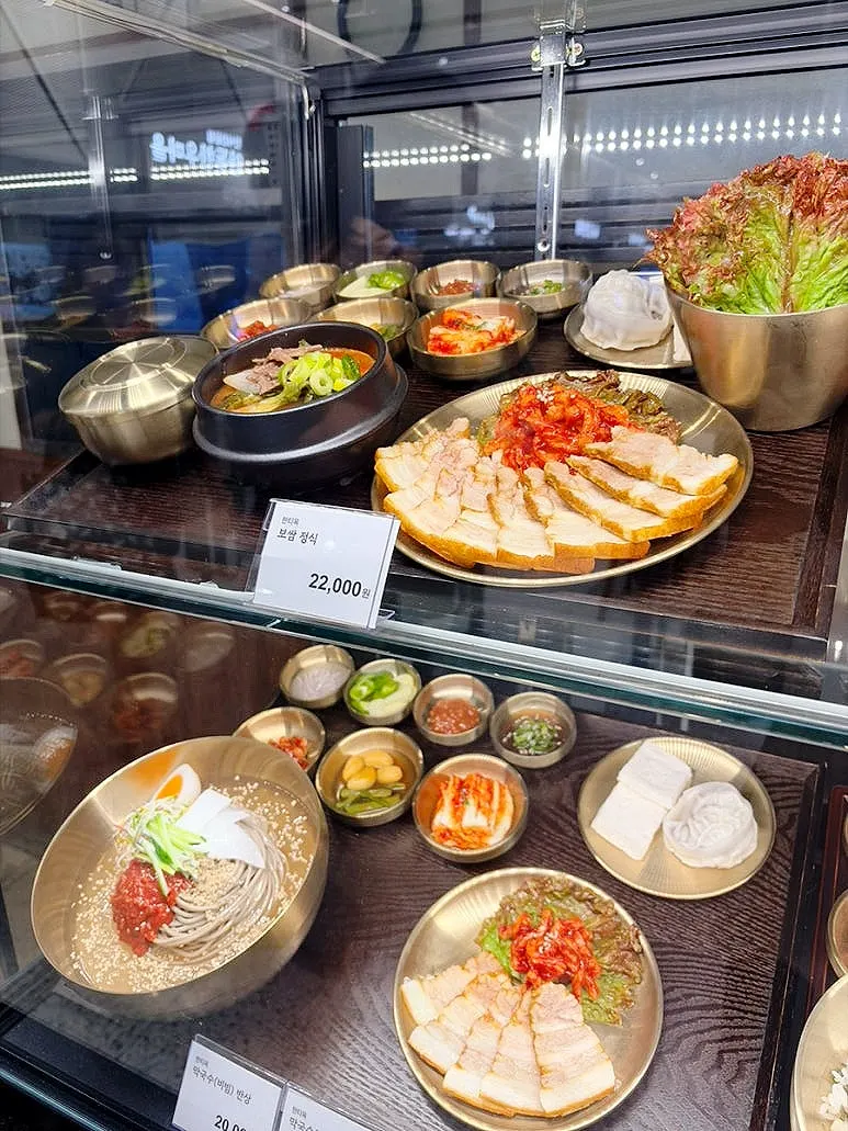 Menu board showing bibimbap, makguksu and bossam options