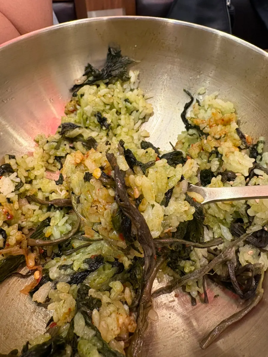 Mixing seasoning sauce into gondre bibimbap
