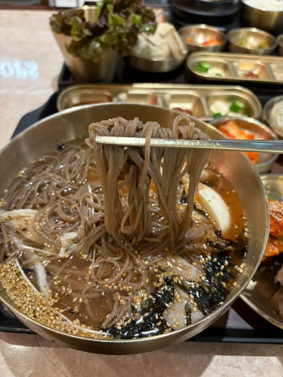 A bite of bossam topped with kimchi