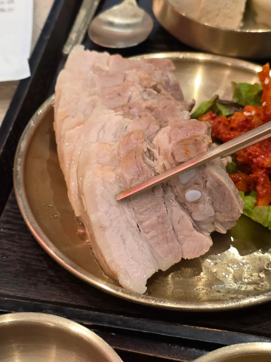 Tender bossam meat lifted with chopsticks