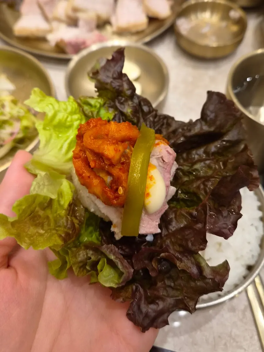 보쌈 한 점과 무김치 곁들임