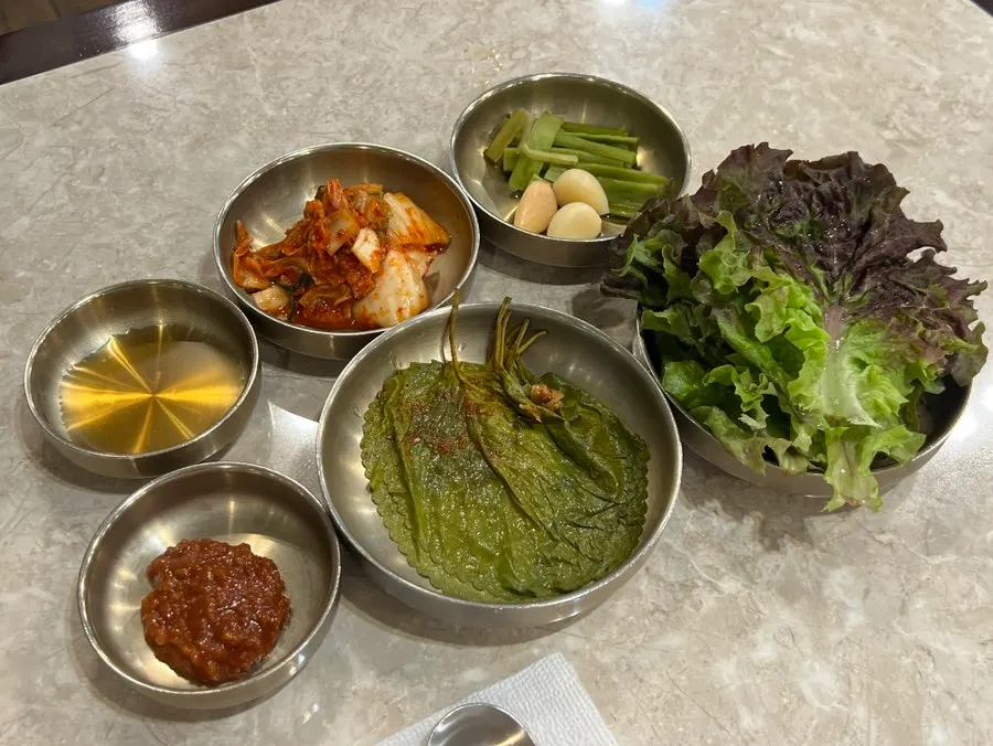 Side dishes including pickled green onion and perilla leaf pickle