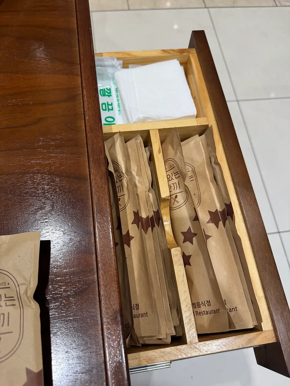 Individually wrapped utensils beside the table