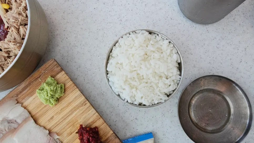 공기밥 위에 돔베고기 올린 아이 식사