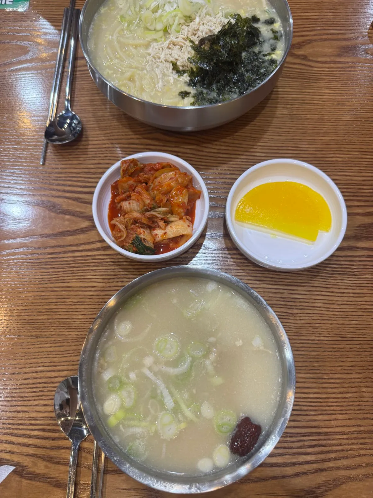 Table set with chicken gomtang and a double portion of egg chicken kalguksu