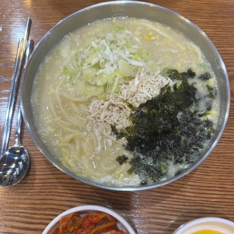 Chicken kalguksu topped with egg, seaweed flakes, and meat