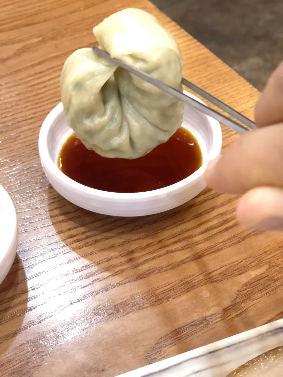 A bite of wang mandu paired with dak kalguksu