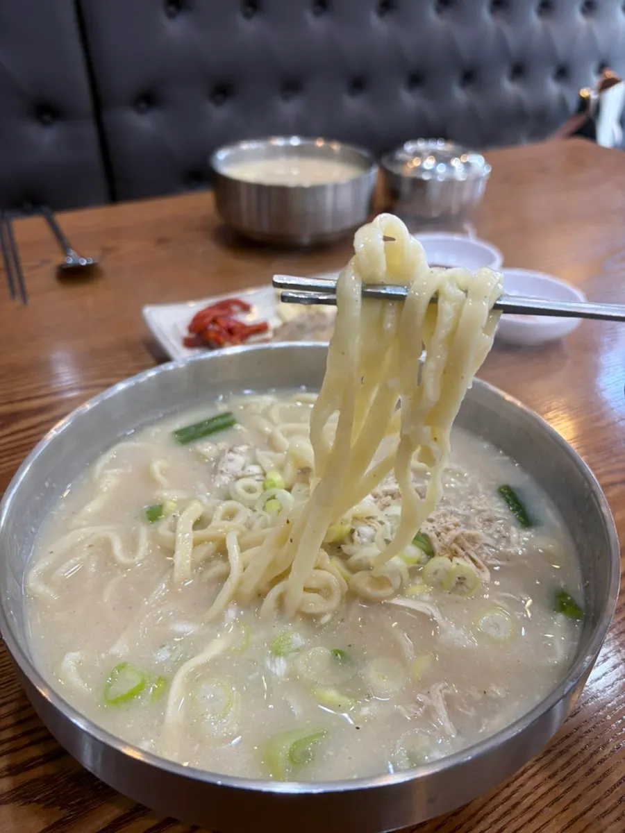 Hand-cut kalguksu noodles lifted out of the broth