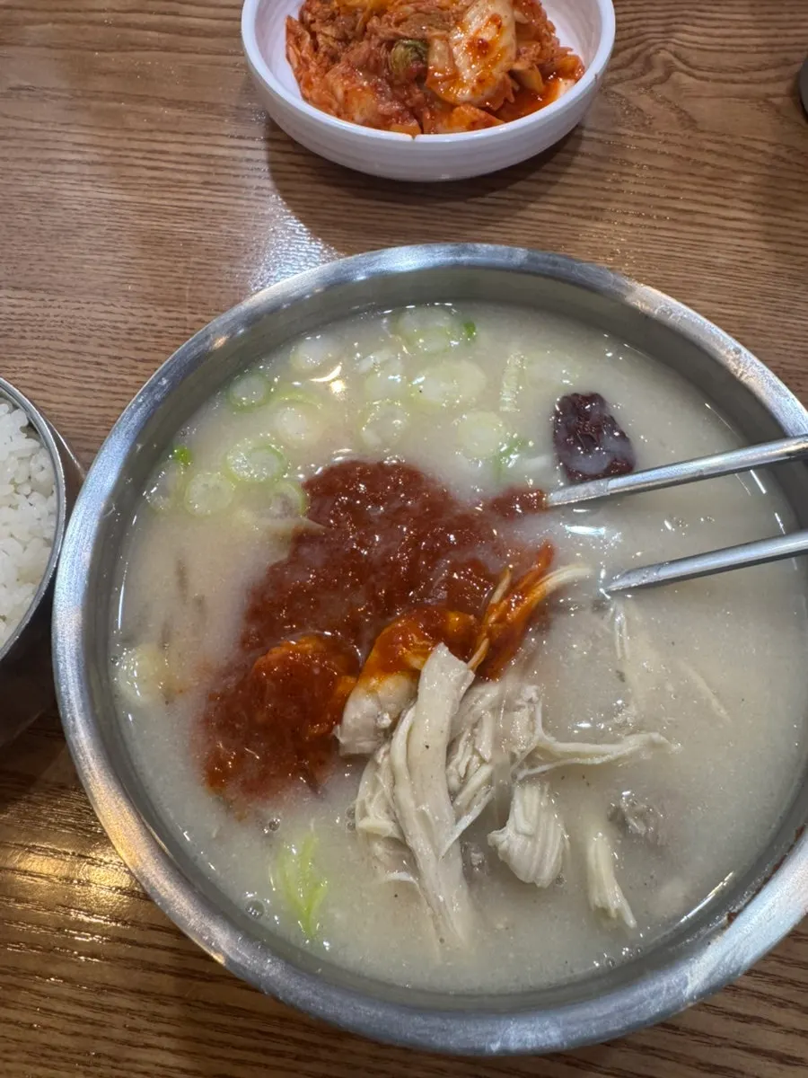 Hot stone bowl of spicy chicken gomtang with glass noodles and scallions