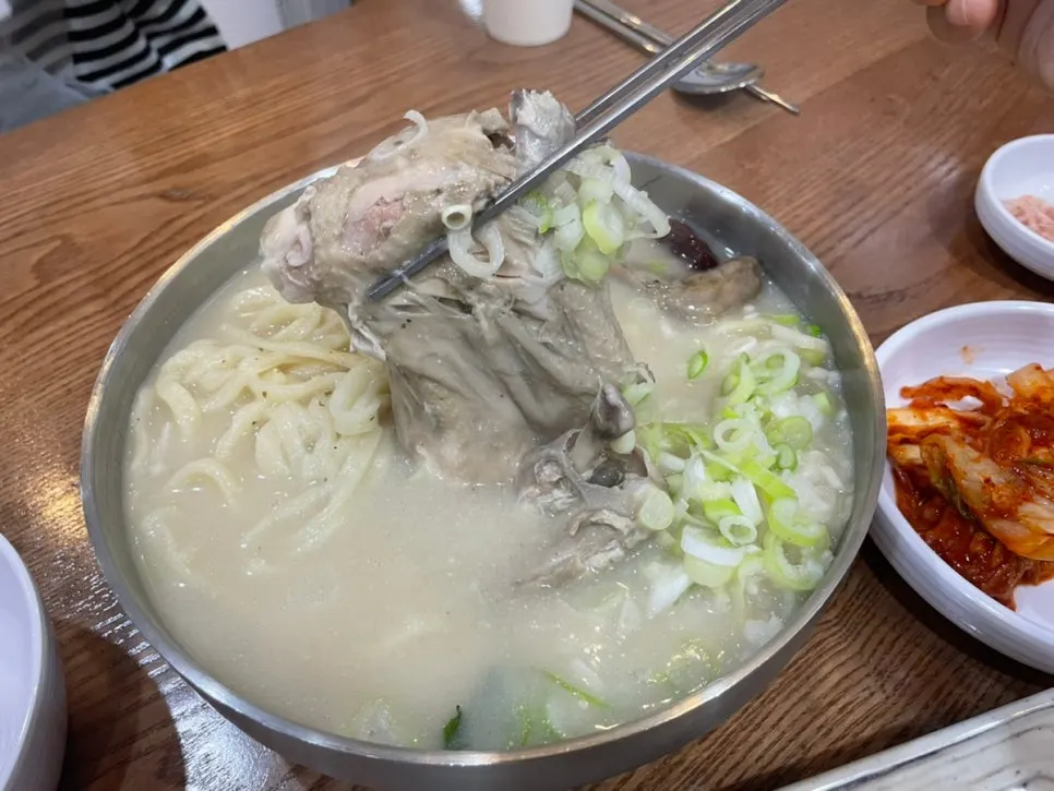 Half a chicken and ginseng sprout inside samgyetang kalguksu