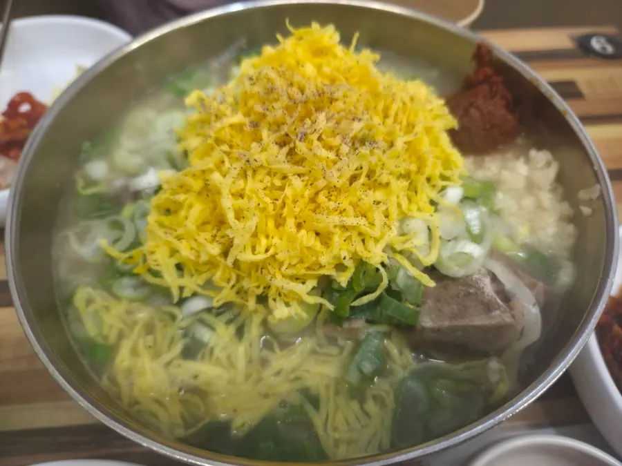 Spicy bone kalguksu piled high with egg ribbon garnish
