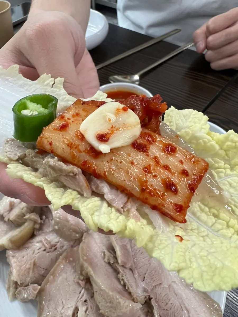 A bite of bossam wrapped in napa cabbage