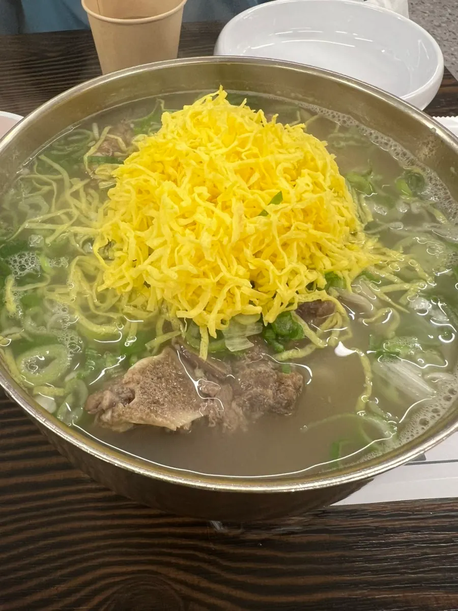 A bowl of bone kalguksu brimming with broth