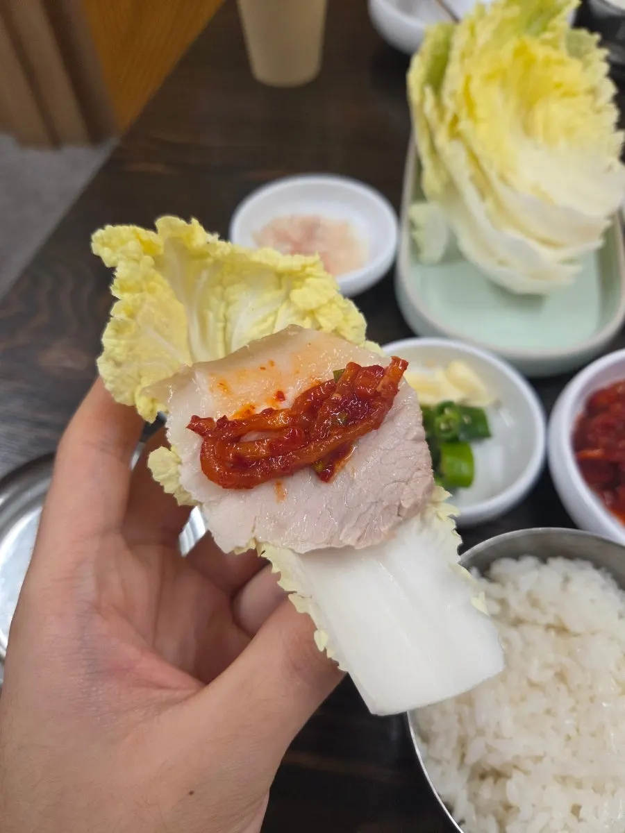 배추에 올린 보쌈 수육 한 입 쌈