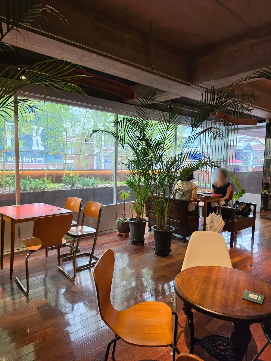 Café seating lit by sunlight through floor-to-ceiling windows