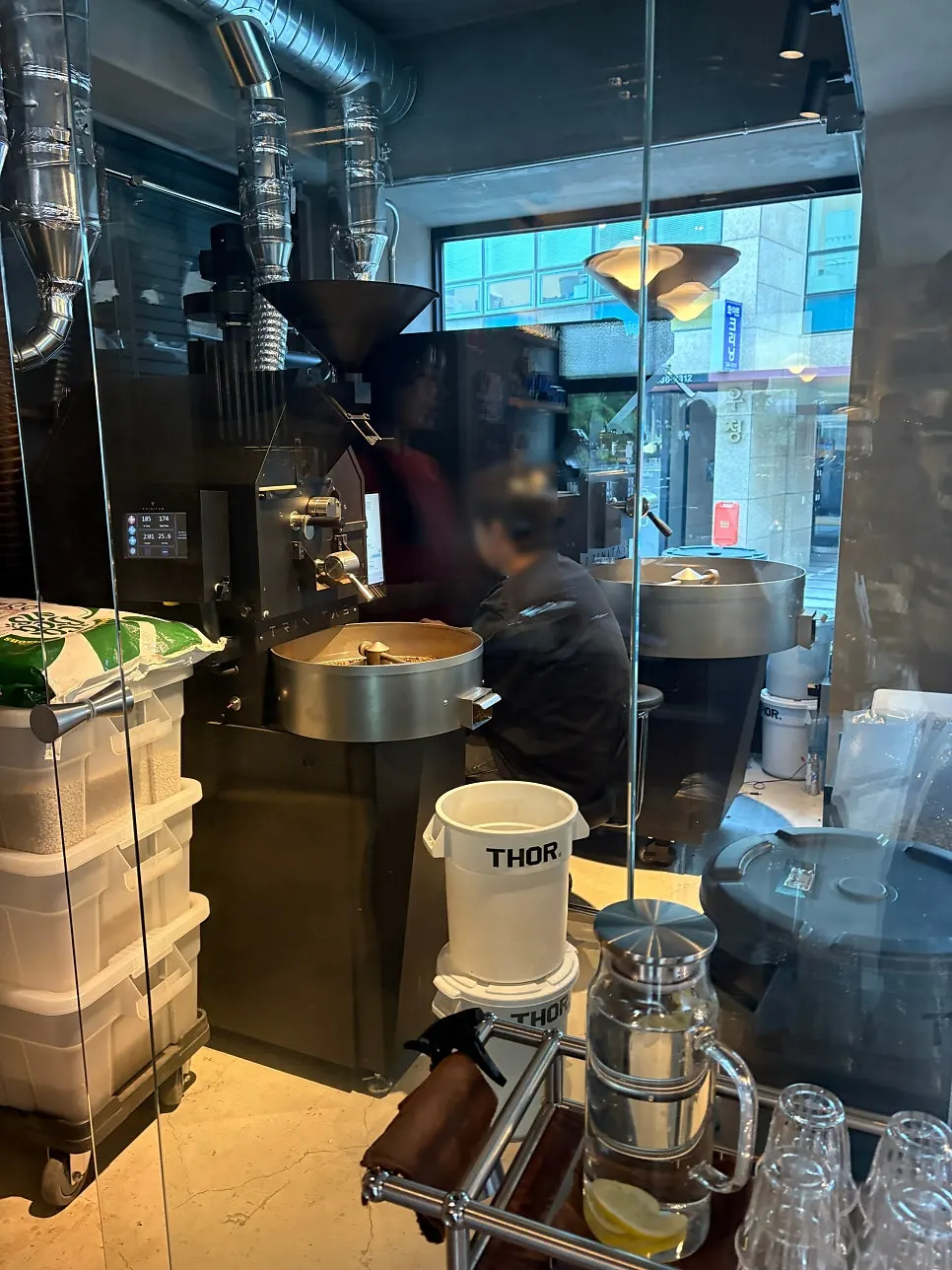 A large roasting machine at the back of the shop