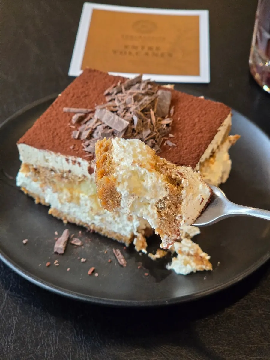 A soft bite of classic tiramisu lifted with a fork