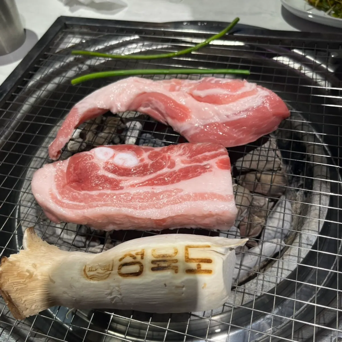 Pork belly and rib meat on a charcoal grill