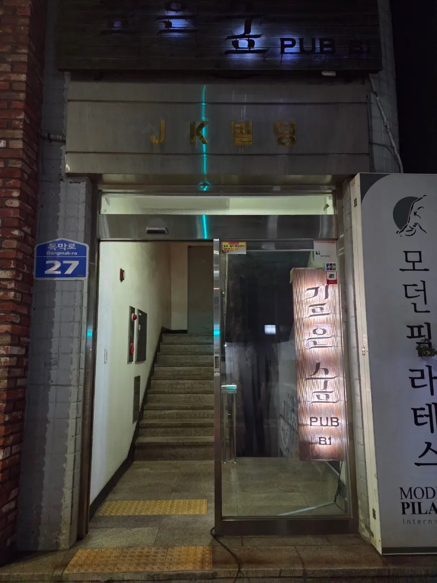 路地奥の地下入口にある木製の看板