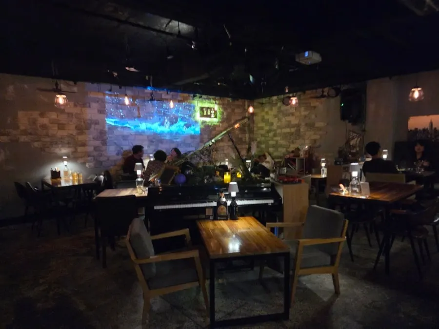 暗めの照明とプロジェクター映像が流れる地下店内