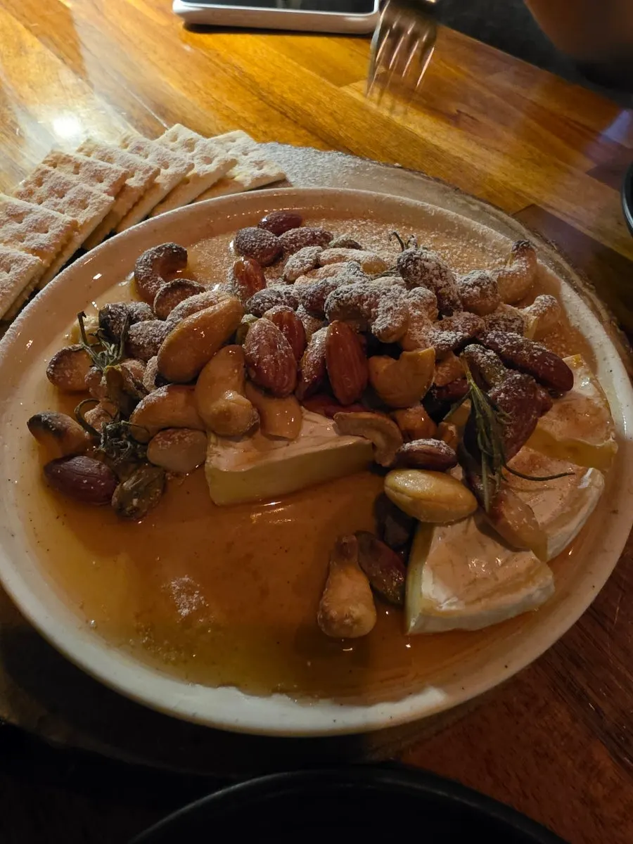 Camembert cheese topped with maple syrup and nuts