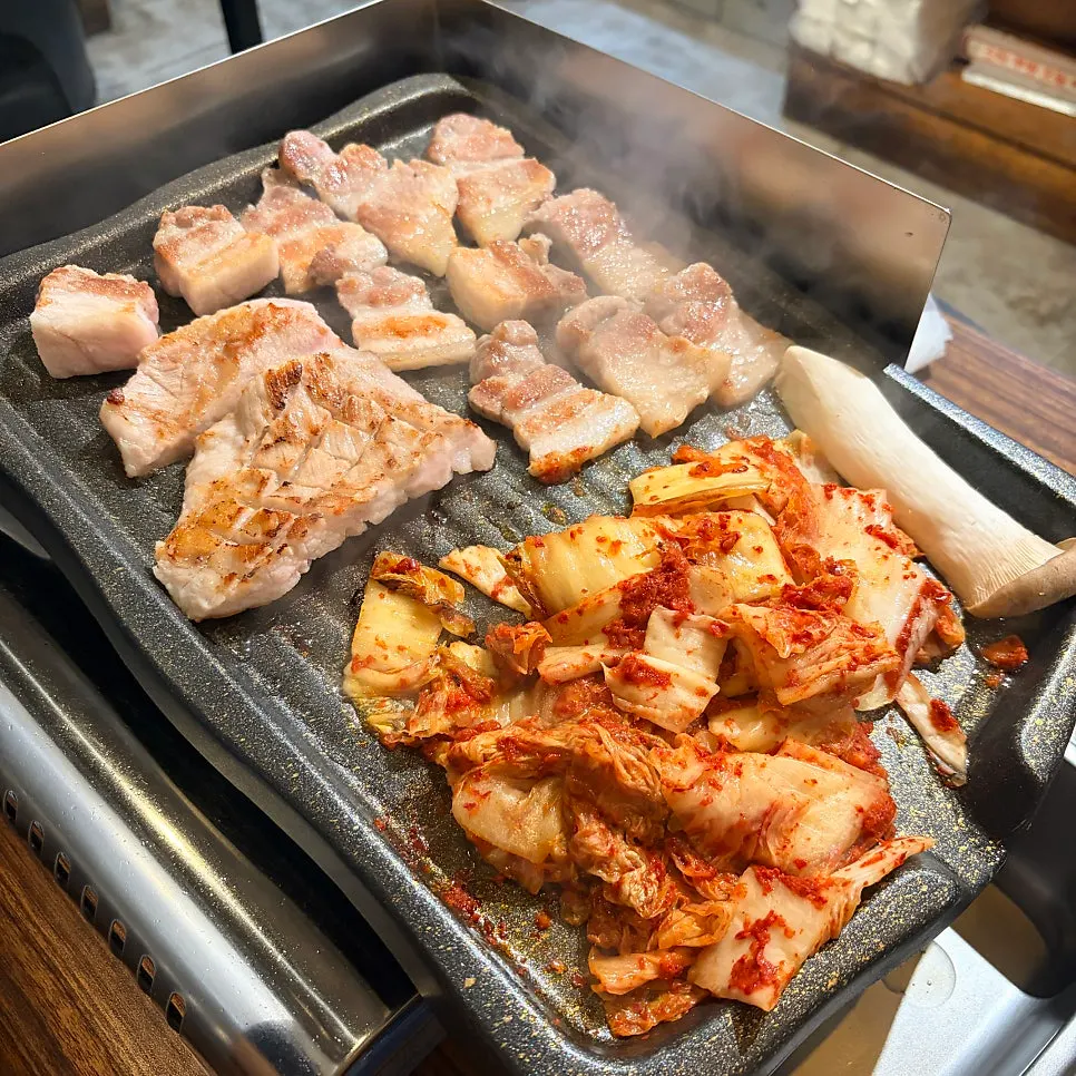 Kimchi and meat cooking on the grill