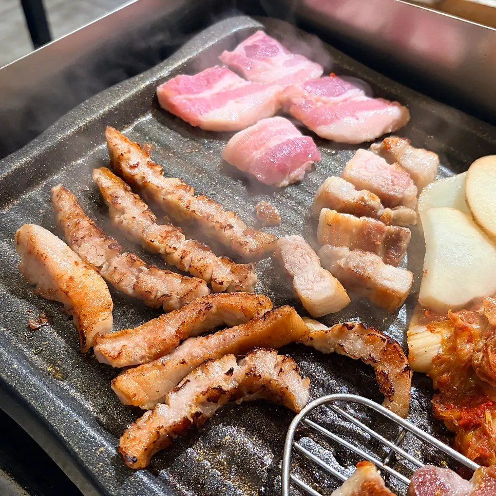Long-cut pork jowl cooking on the grill