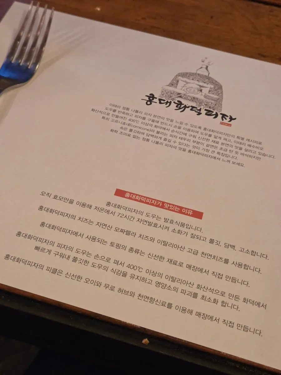 In-store signage explaining the wood-fired pizza