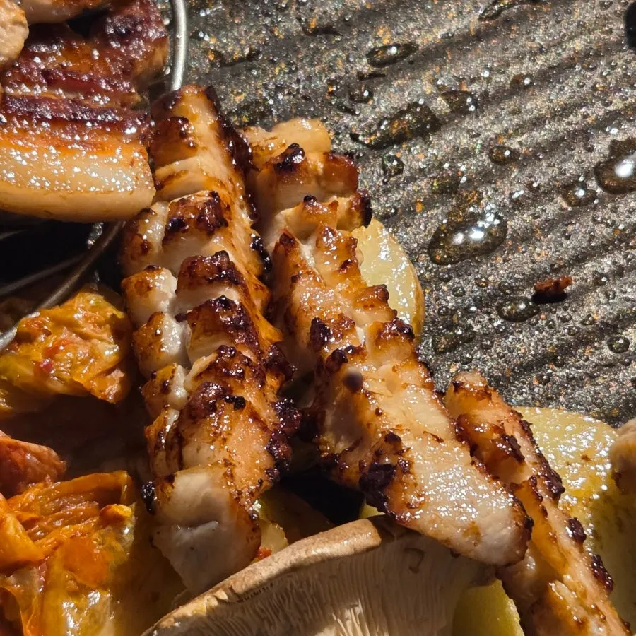 Well-cooked meat moved to the side of the grill