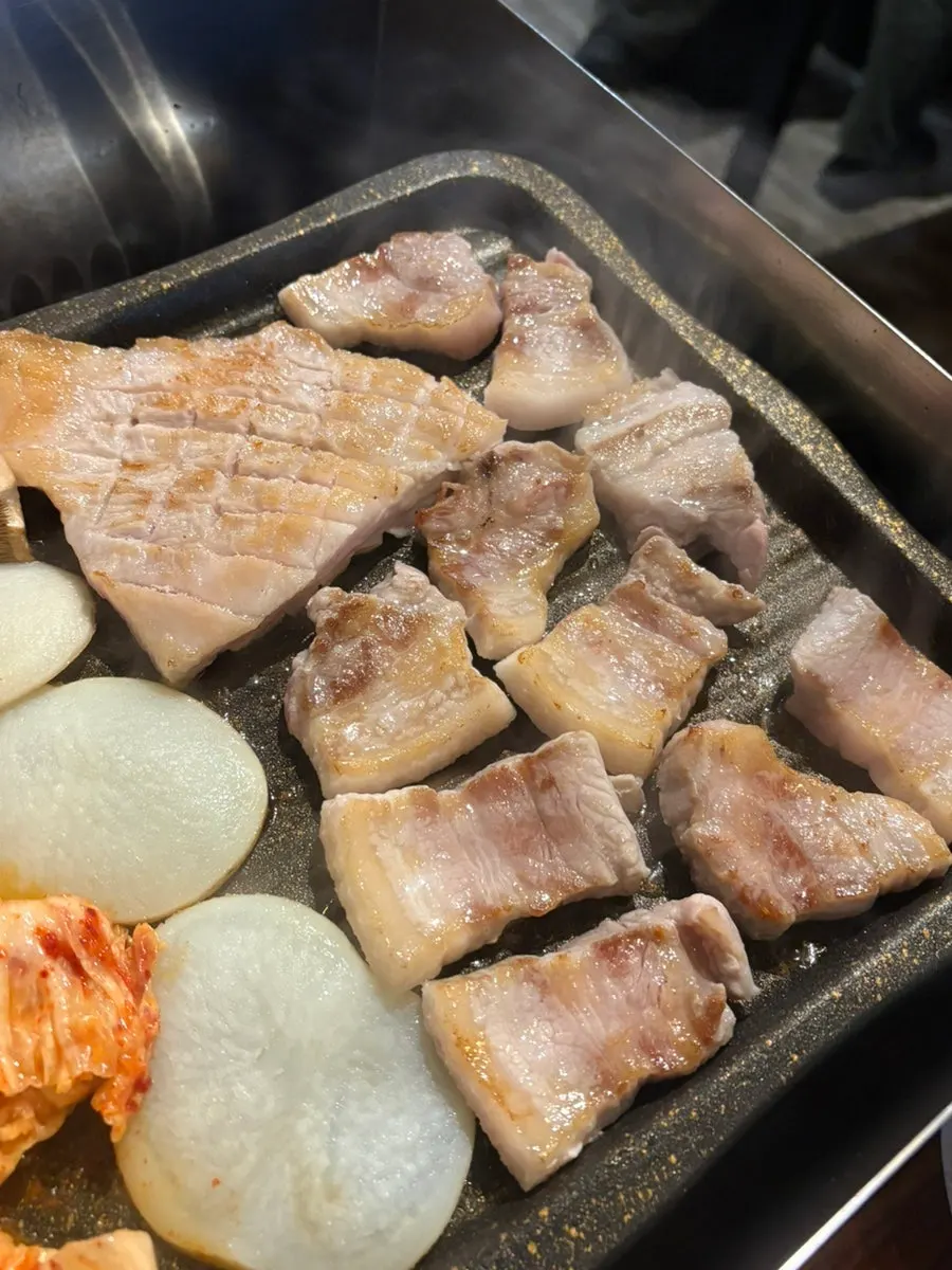 Staff grilling raw pork belly on the grill
