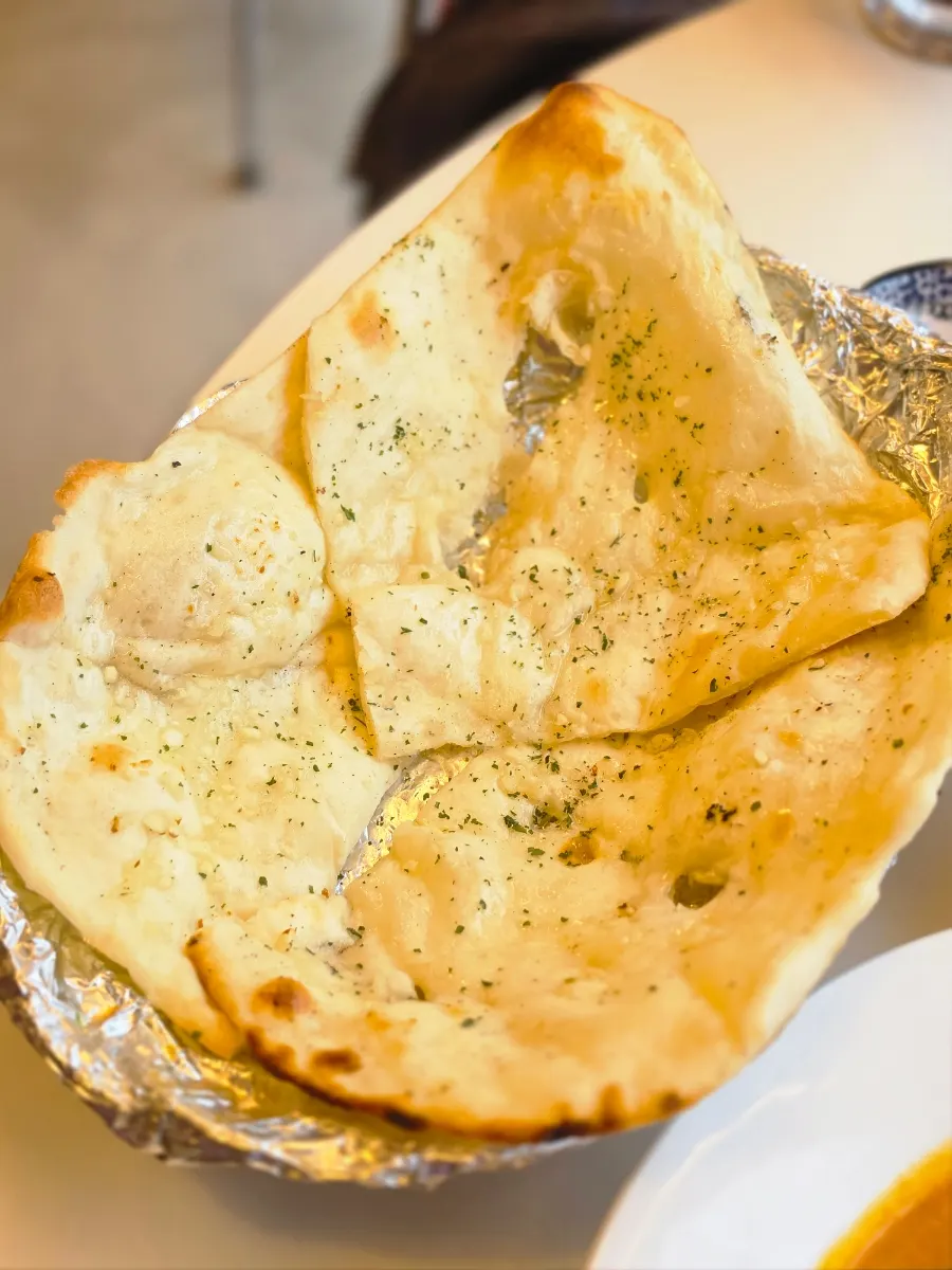 Naan being dipped into the curry