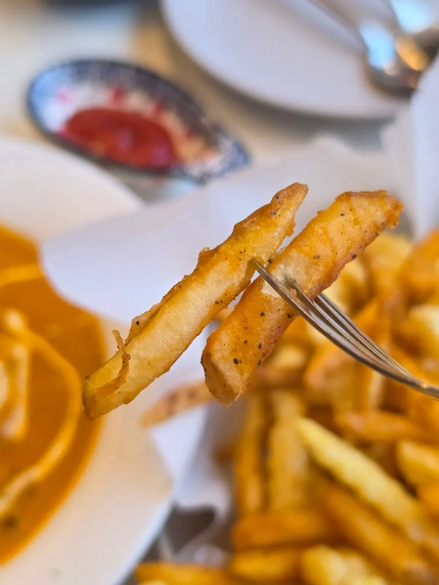 A piece of garlic naan dipped in curry