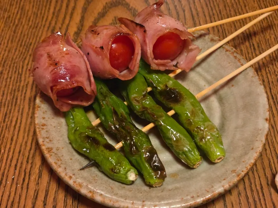 Skewers of tomato bacon roll and grilled shishito peppers
