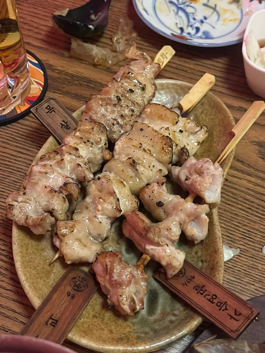Friends serving themselves skewers over drinks