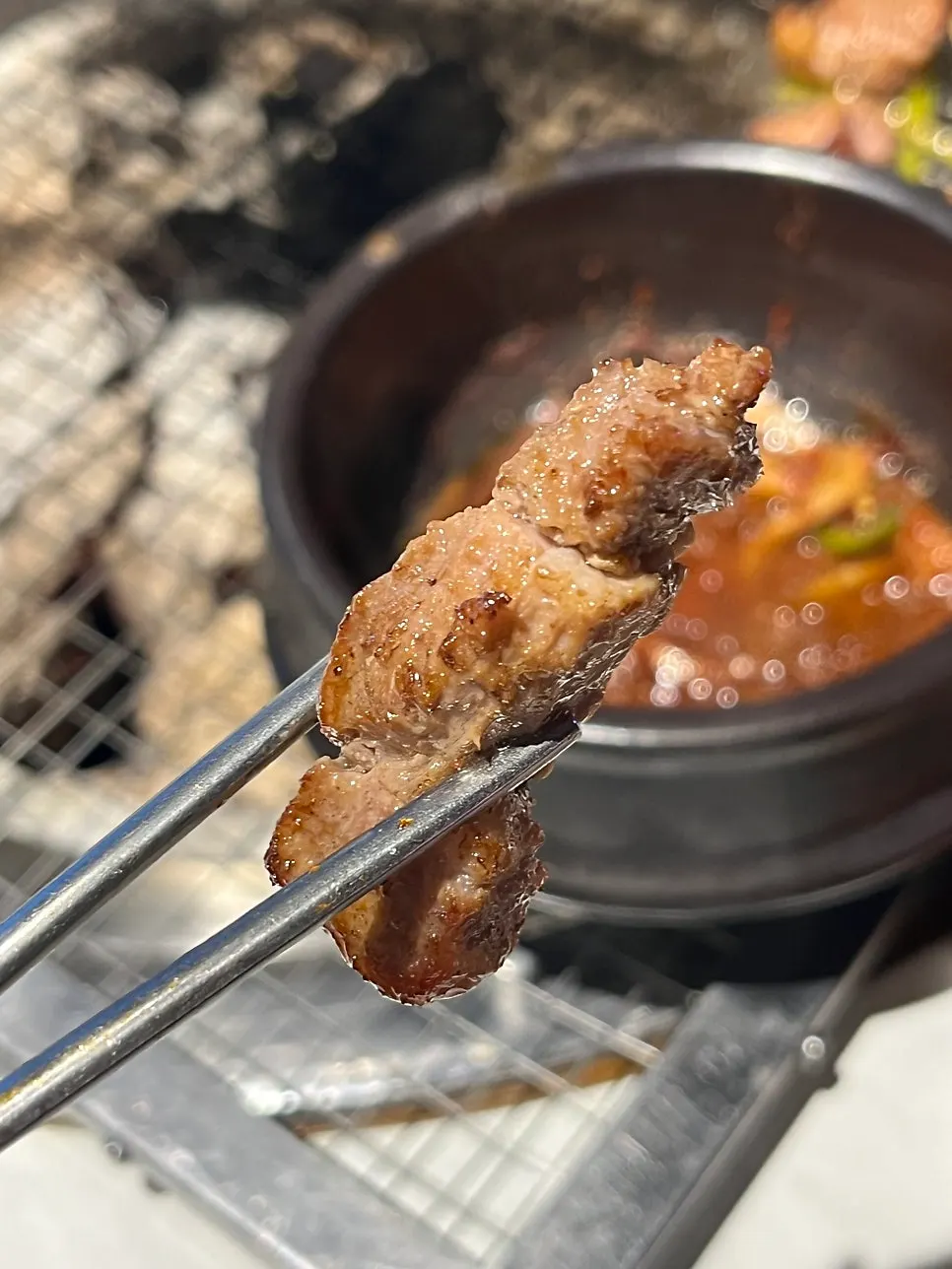 A piece of kkotmoksal held with chopsticks