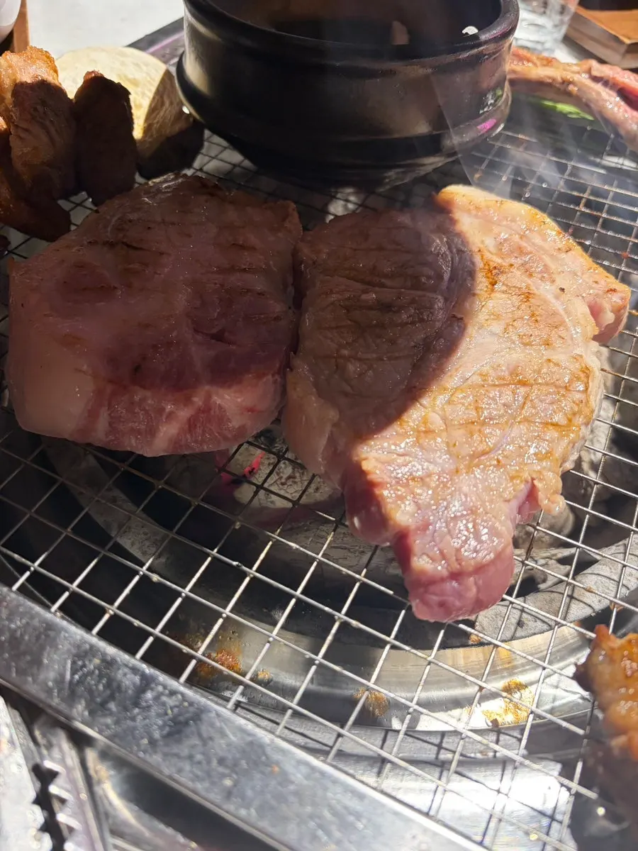 Bone-in pork belly and king oyster mushrooms browning nicely