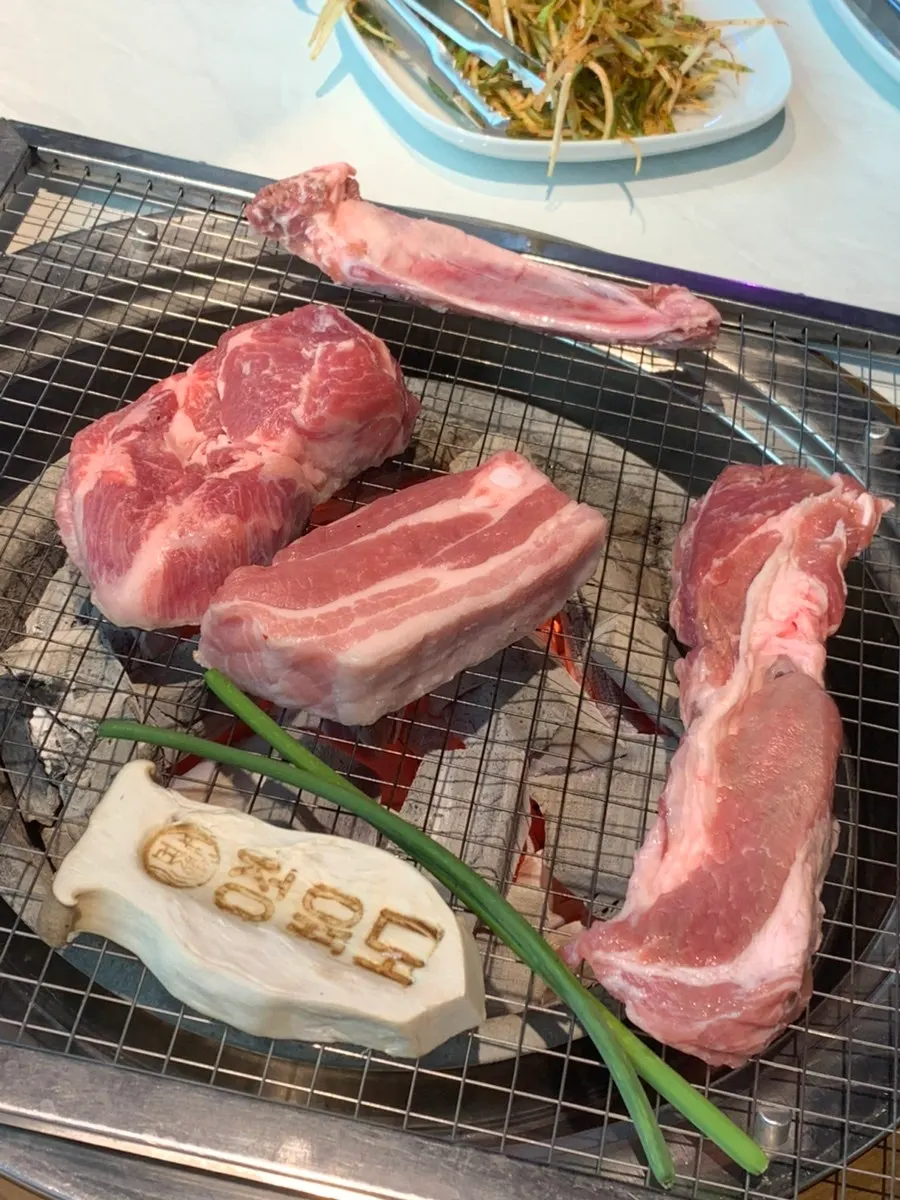 Pork belly, pork neck, and fresh ribs on the grill