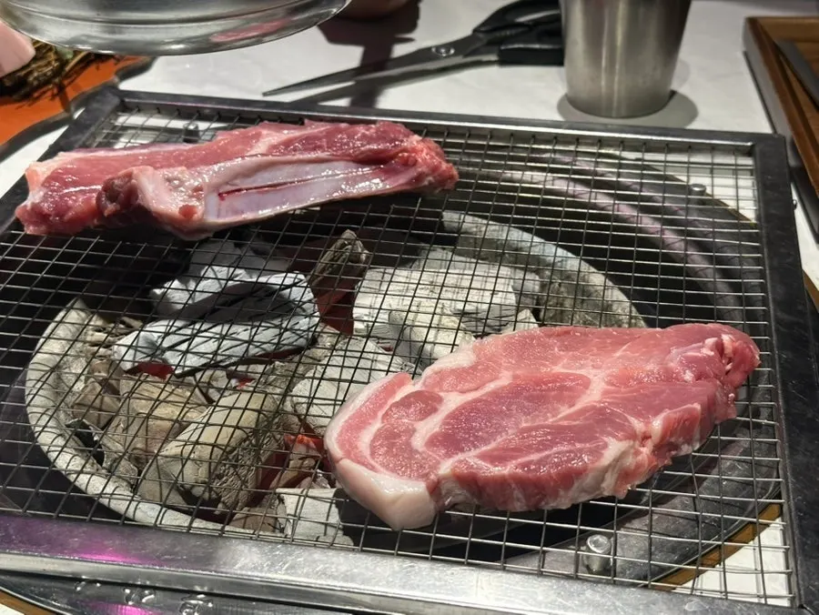 Pork belly and neck cooking on the grill