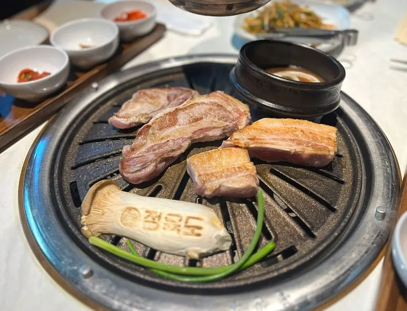 Meat being placed on the grill to cook