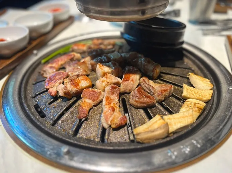 Meat cut into bite-sized pieces with cut surfaces being grilled