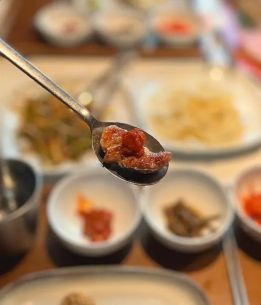 A piece of pork neck topped with squid jeotgal