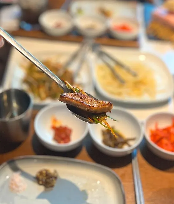 A piece of meat topped with scallion salad