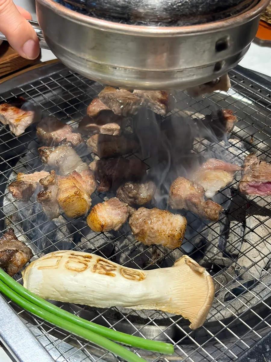 연기를 빨아들이는 후드 아래 숯불 화로