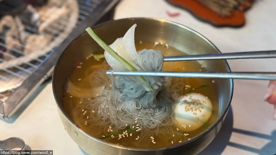 Close-up of noodles lifted from the mul naengmyeon bowl