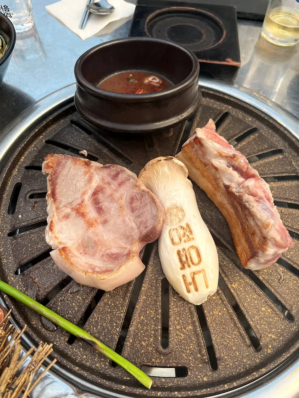 Pork on the grill with king oyster mushroom and garlic scapes